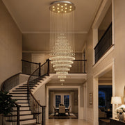 modern round crystal chandelier staircase lighting fixture hanging above curved staircase in luxury home | Feyran