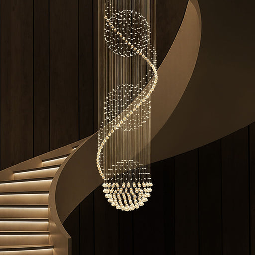 modern spiral three sphere raindrop crystal chandelier lighting hanging over curved staircase in luxury interior | Feyran